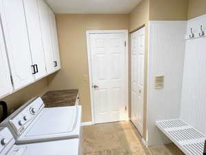 Washroom with cabinet space and washer and clothes dryer