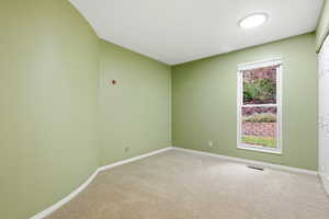 Carpeted spare room with baseboards
