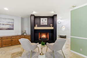 Sitting room with a brick fireplace and recessed lighting