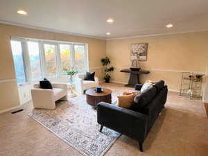 Living area featuring crown molding, recessed lighting, and carpet flooring