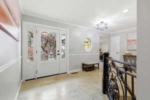 Foyer entrance featuring ornamental molding and healthy amount of natural light