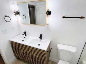Bathroom featuring double vanity and toilet