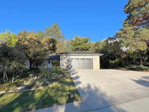 View of front of house featuring concrete driveway, brick siding, and an attached garage