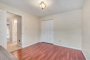 Unfurnished bedroom featuring wood finished floors and a closet