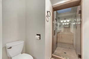 Full bath with toilet and a shower stall