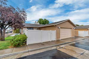 View of home's exterior featuring brick siding, driveway, roof with shingles, and a garage