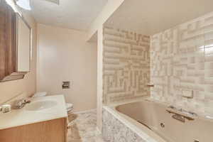 Full bath featuring vanity and a textured ceiling