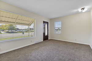 Foyer entrance featuring carpet and baseboards