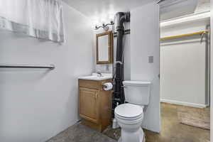 Half bath featuring vanity and concrete floors