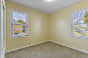 Unfurnished room featuring light colored carpet and baseboards