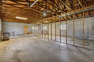 Garage featuring concrete block wall and a garage door opener
