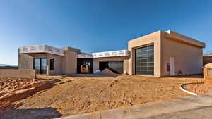 View of front of house featuring stucco siding and a garage