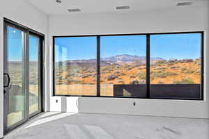 Empty room with a mountain view and unfinished concrete flooring