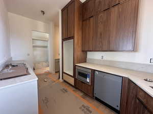 Kitchen with stainless steel appliances, light wood-style floors, light stone countertops, modern cabinets, and wood finish cabinets