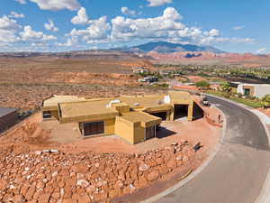 Aerial view of property and surrounding area featuring a mountainous background