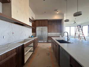 Kitchen featuring dishwasher, ceiling fan, light stone counters, decorative light fixtures, and tasteful backsplash