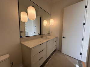 Half bath with vanity and unfinished concrete flooring