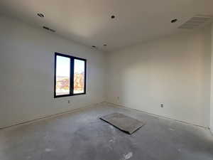 Unfurnished room featuring unfinished concrete flooring