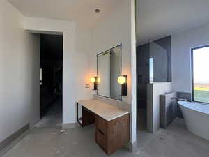 Bathroom featuring a soaking tub, walk in shower, light tile patterned floors, and vanity
