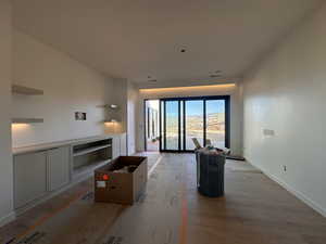 Unfurnished living room with baseboards and wood finished floors