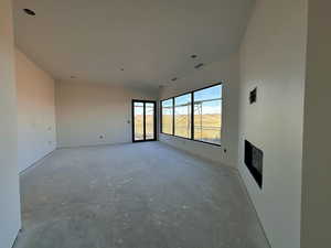 Unfurnished living room with concrete floors and a fireplace