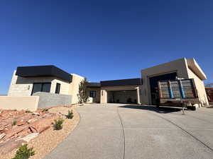 Contemporary house featuring stucco siding, an attached garage, and driveway
