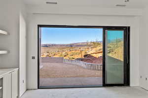 Doorway to outside with a mountain view and unfinished concrete floors