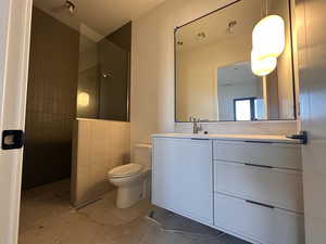 Full bath featuring vanity, a walk in shower, and light tile patterned flooring