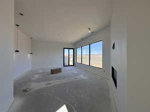 Spare room with unfinished concrete flooring and baseboards