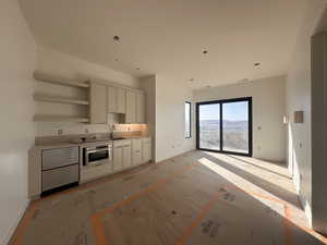 Kitchen with open shelves, light countertops, stainless steel oven, light wood finished floors, and recessed lighting