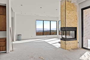 Unfurnished living room with a multi sided fireplace, a mountain view, and recessed lighting