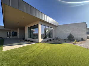 Back of property featuring a yard, stucco siding, and a patio area