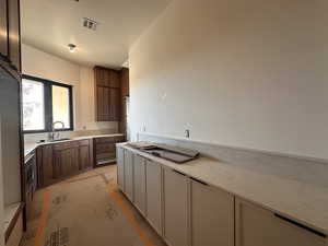 Kitchen with light stone countertops and two tone color scheme