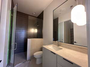 Bathroom featuring vanity, a shower stall, and light tile patterned floors