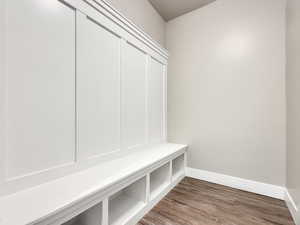 Mudroom with dark wood-style flooring and baseboards