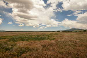 View of undeveloped land featuring a mountainous background and rural landscape