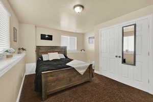 Carpeted bedroom with multiple windows and a textured ceiling