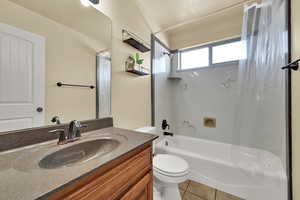 Bathroom with shower / tub combo with curtain, vanity, and light tile patterned floors