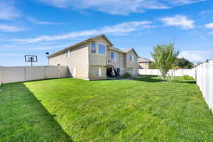 Rear view of property featuring stucco siding and a fenced backyard