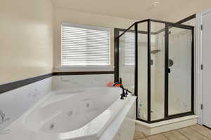 Bathroom with a stall shower, a whirlpool tub, and light tile patterned floors