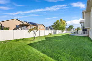 Fenced backyard featuring a residential view and a balcony