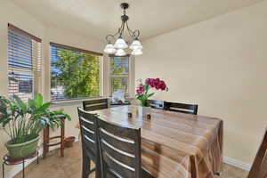 Dining room featuring light tile patterned floors and a chandelier