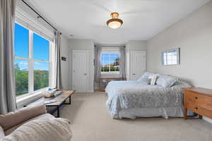 Carpeted bedroom with two closets and baseboards