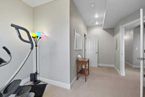 Corridor with light carpet and baseboards