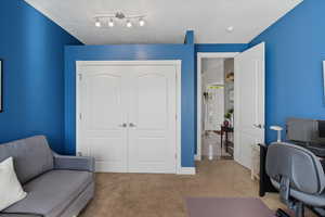 Carpeted home office featuring baseboards