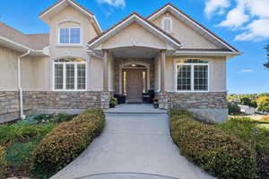 View of exterior entry with stone siding and stucco siding