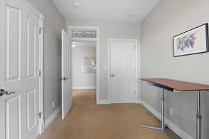 Hall featuring light carpet and baseboards