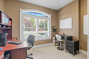 Home office with baseboards and light carpet