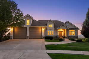 View of front of home featuring stone siding, a front yard, stucco siding, and concrete driveway