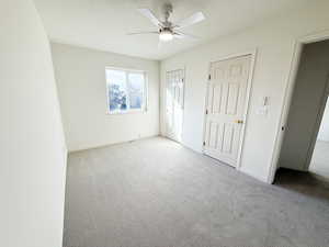 Unfurnished bedroom featuring carpet flooring, a ceiling fan, and multiple closets